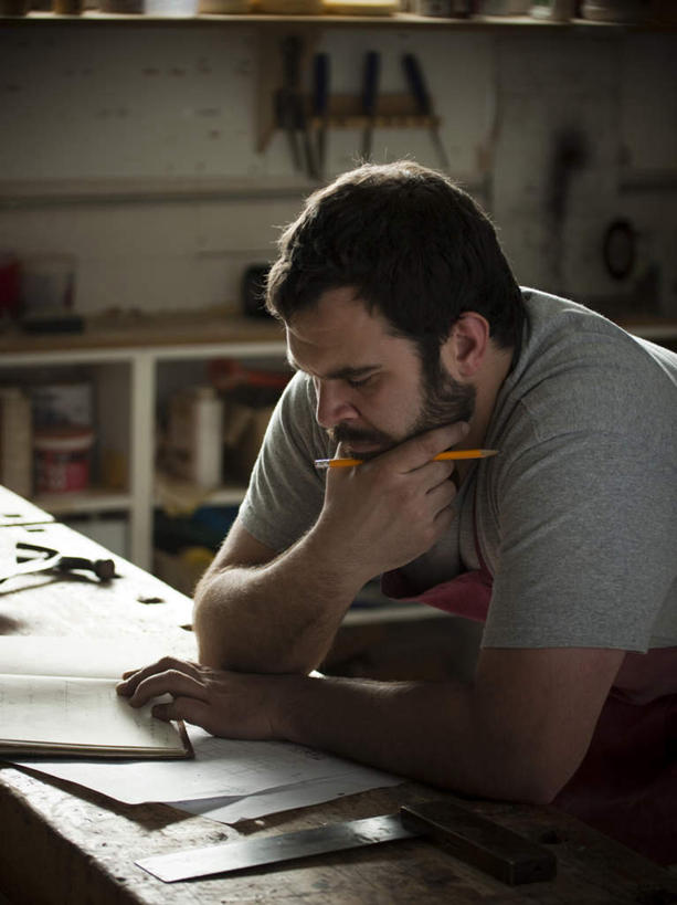 西方人,一个人,木匠,坐,竖图,室内,白天,正面,T恤衫,欧洲,欧洲人,仅一个男性,仅一个人,仅一个中年男性,撑,握,阴影,反射,木材,木框,围裙,影子,墙,拿,T恤,拿着,托腮,注视,墙壁,墙面,木柴,红色,低头,观察,看,托,握着,木料,观看,察看,操作,关注,托下巴,男人,男性,中年男性,白种人,木工,坐着,半身,彩图