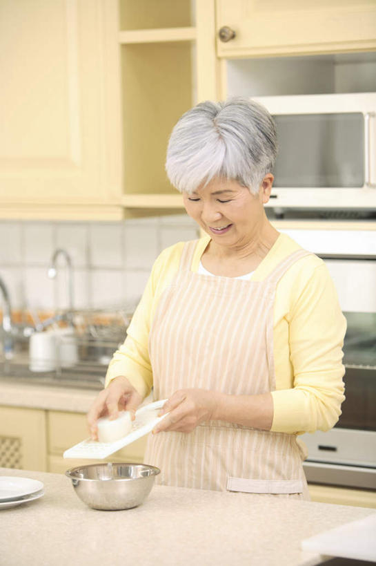 东方人,一个人,站,笑,微笑,露齿笑,竖图,室内,白天,正面,厨房,柜子,餐具,亚洲,仅一个女性,仅一个人,刨丝器,水龙头,食品,储物柜,拿,拿着,注视,黄种人,开关,砧板,食物,橱柜,打开,低头,观察,看,站着,日本人,仅一个老年女性,观看,阀门,察看,开启,储存,关注,水咀,储备,蕴藏,贮备,老年女性,女人,女性,亚洲人,进餐用具,烹调用具,站立,半身,彩图,灶间,贮存