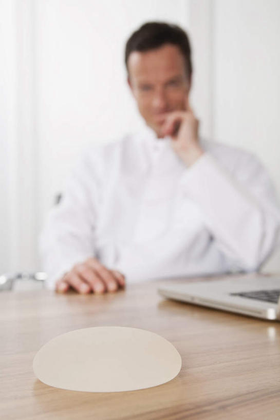 西方人,胸,一个人,医生,医院,坐,竖图,室内,白天,正面,电脑,笔记本电脑,桌子,欧洲,欧洲人,仅一个男性,仅一个人,仅一个中年男性,撑,网络,办公桌,托腮,注视,通讯设备,观察,看,托,医护人员,医疗人员,观看,察看,硅胶,无线,白大褂,关注,托下巴,通信设备,无线网络,无线上网,便携式电脑,整容,整形,医疗机构,隆胸,手提电脑,男人,男性,中年男性,白种人,胸部,大夫,坐着,半身,彩图,病院,诊所