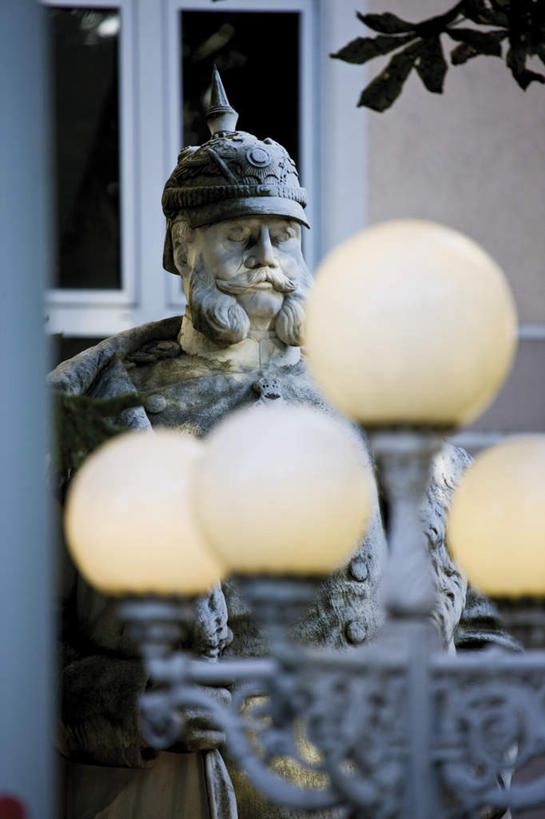 西方人,一个人,无人,站,竖图,室外,白天,正面,旅游,度假,植物,窗户,标志建筑,地标,建筑,路灯,帽子,叶子,照明,雕塑,德国,欧洲,欧洲人,仅一个男性,仅一个人,艺术,装饰,雕刻,雕像,头盔,灯光,绿叶,注视,娱乐,建设,玻璃窗,灯,树,树木,绿色,自然,安全帽,工艺品,观察,看,站着,仅一个老年男性,享受,休闲,嫩叶,旅游胜地,放松,生长,成长,观看,纪念,照亮,美术,察看,国王,照明设备,西欧,关注,主题,陈列,德意志联邦共和国,功能,美学,北威州,北莱茵.威斯特法伦州,波恩,威廉公爵,威廉一世,征服者威廉,诺曼底公爵,英格兰国王,老年男性,男人,男性,白种人,叶,叶片,站立,半身,彩图