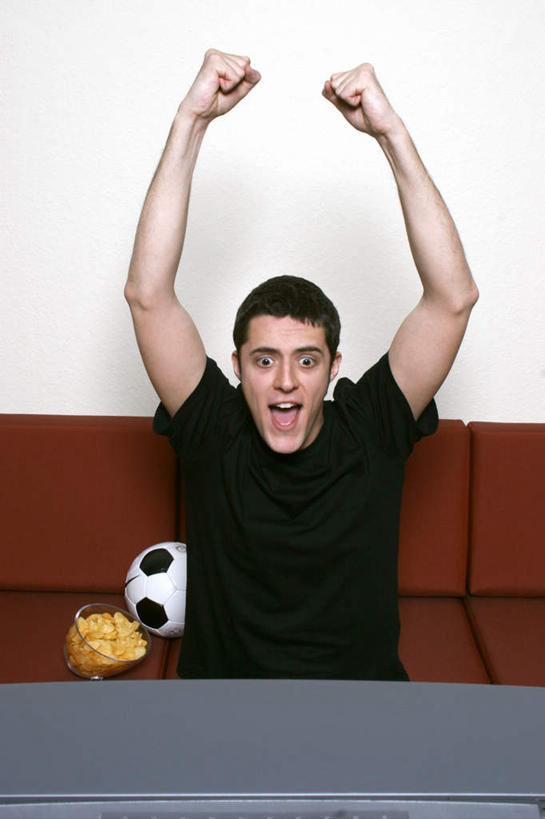 西方人,一个人,坐,举,伸展双臂,竖图,室内,白天,正面,T恤衫,兴奋,足球,沙发,欧洲,欧洲人,仅一个男性,仅一个人,服装,欢呼,足球装备,T恤,注视,休闲装,运动器械,仅一个年轻男性,衣服,黑色,观察,看,托,休闲,休闲服,健身器械,服饰,观看,察看,喝彩,关注,健身器材,布艺沙发,蹴鞠,足球运动,男人,男性,年轻男性,白种人,敞开双臂,举起,举手,举着,伸开双臂,向上举,向上伸,向上托,展开双肩,张开手臂,张开双臂,坐着,半身,彩图,运动器材