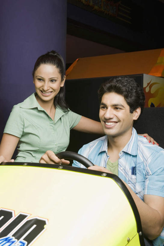 两个人,夫妻,站,坐,笑,微笑,露齿笑,竖图,室内,白天,正面,爱情,游戏,赛车,亚洲,握,服装,墙,浪漫,玩,注视,休闲装,娱乐,墙壁,墙面,衣服,方向盘,观察,看,站着,休闲,休闲服,恩爱,握着,恋人,服饰,游戏机,观看,察看,关注,男人,男性,女人,女性,中年男性,中年女性,亚洲人,印度人,情侣,玩耍,嬉戏,坐着,半身,彩图,伴侣