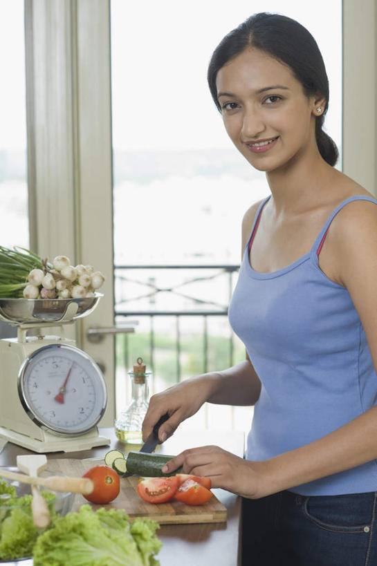 一个人,栏杆,站,笑,微笑,露齿笑,竖图,室内,白天,侧面,仪器,餐桌,厨房,窗户,落地窗,桌子,黄瓜,蔬菜,蒜,西红柿,金属制品,亚洲,仅一个年轻女性,仅一个女性,仅一个人,握,服装,新鲜,金属,工具,围栏,生菜,食品,案板,刀具,电子秤,拿,蒜头,拿着,注视,休闲装,护栏,玻璃窗,砧板,食物,衣服,刀,观察,看,站着,休闲,休闲服,握着,服饰,有机食品,绿色食品,餐台,观看,察看,衡量,关注,菜刀,计量,衡器,切菜刀,胡蒜,年轻女性,女人,女性,亚洲人,印度人,秤,青瓜,胡瓜,番茄,大蒜,站立,半身,彩图,灶间,电子称