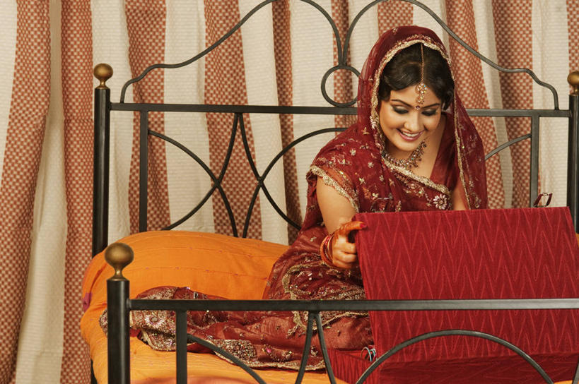 一个人,新娘,坐,笑,盘腿,微笑,露齿笑,横图,室内,白天,正面,民族服装,婚礼,快乐,窗帘,床,卧室,项链,亚洲,仅一个年轻女性,仅一个女性,仅一个人,庆祝,装饰,双人床,橘黄色,床单,结婚,注视,被子,首饰盒,盒子,装饰品,红色,帘子,容器,饰品,首饰,扶,观察,看,喜庆,遮阳,服饰,观看,纪念,飘逸,储藏,华丽,修饰,点缀,察看,被单,扶着,庄重,储存,关注,追求,纱丽,衬托,美观,雅致,雅观,纱丽服,清婉,妍丽,年轻女性,女人,女性,亚洲人,印度人,盘腿而坐,盘膝,盘着腿的,盘着腿坐,双腿交叉,坐着,彩图,全身,传统服装,民俗服,高兴,睡房,卧房,贮存,奢华