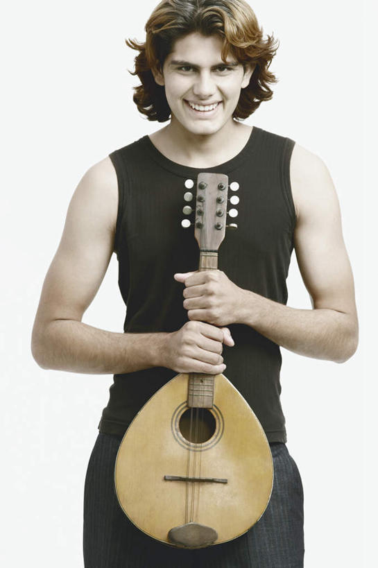 一个人,站,笑,微笑,露齿笑,竖图,室内,白天,白色背景,正面,亚洲,仅一个男性,仅一个人,握,服装,褐色,乐器,弦乐器,拿,拿着,注视,休闲装,腰带,仅一个年轻男性,衣服,观察,看,站着,休闲,休闲服,握着,摄影,服饰,影棚,观看,皮带,察看,关注,弹拨弦鸣乐器,配饰,裤带,班卓琴,男人,男性,年轻男性,亚洲人,印度人,站立,半身,彩图,影棚拍摄,拍摄,弹拨弦乐器