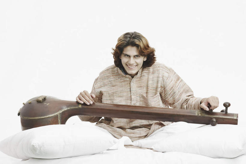 一个人,坐,盘腿,横图,室内,白天,白色背景,正面,民族服装,靠垫,亚洲,仅一个男性,仅一个人,握,服装,靠枕,乐器,弦乐器,拿,拿着,注视,仅一个年轻男性,衣服,抱枕,枕头,观察,看,握着,摄影,服饰,影棚,观看,察看,衣着,穿着,关注,弓拉弦乐器,弓拉弦鸣乐器,西塔尔,西塔琴,衣饰,锡塔尔琴,男人,男性,年轻男性,亚洲人,印度人,盘腿而坐,盘膝,盘着腿的,盘着腿坐,双腿交叉,坐着,彩图,全身,影棚拍摄,传统服装,民俗服,拍摄