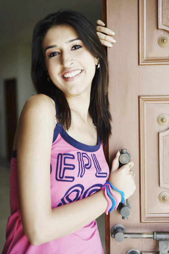 一个人,客厅,站,笑,微笑,露齿笑,竖图,室内,白天,正面,亚洲,仅一个年轻女性,仅一个女性,仅一个人,服装,注视,休闲装,衣服,扶,观察,看,站着,休闲,休闲服,服饰,观看,察看,起居室,扶着,关注,年轻女性,女人,女性,亚洲人,印度人,站立,半身,彩图