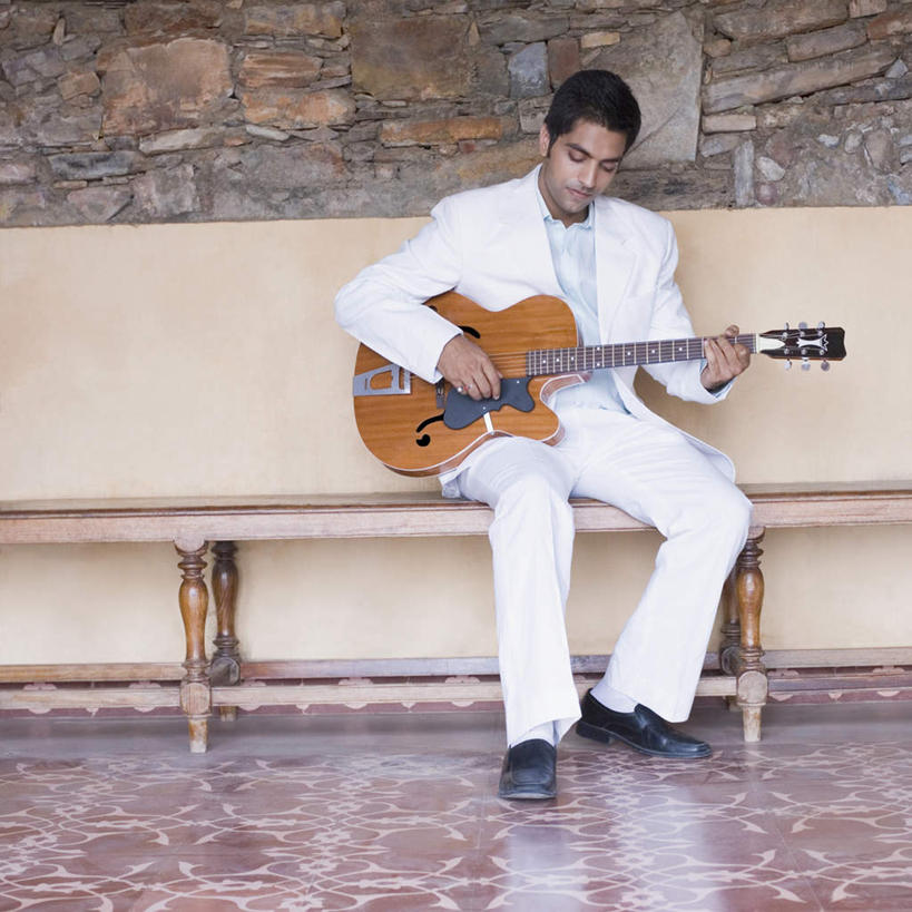 一个人,坐,横图,室内,白天,正面,衬衫,西装,亚洲,仅一个男性,仅一个人,握,套装,服装,正装,吉他,乐器,弦乐器,弹奏,拿,拿着,注视,休闲装,职业装,仅一个年轻男性,衣服,观察,看,休闲,休闲服,弹,握着,服饰,观看,察看,关注,弹拨弦鸣乐器,男人,男性,年轻男性,亚洲人,印度人,坐着,彩图,全身,衬衣,弹拨弦乐器