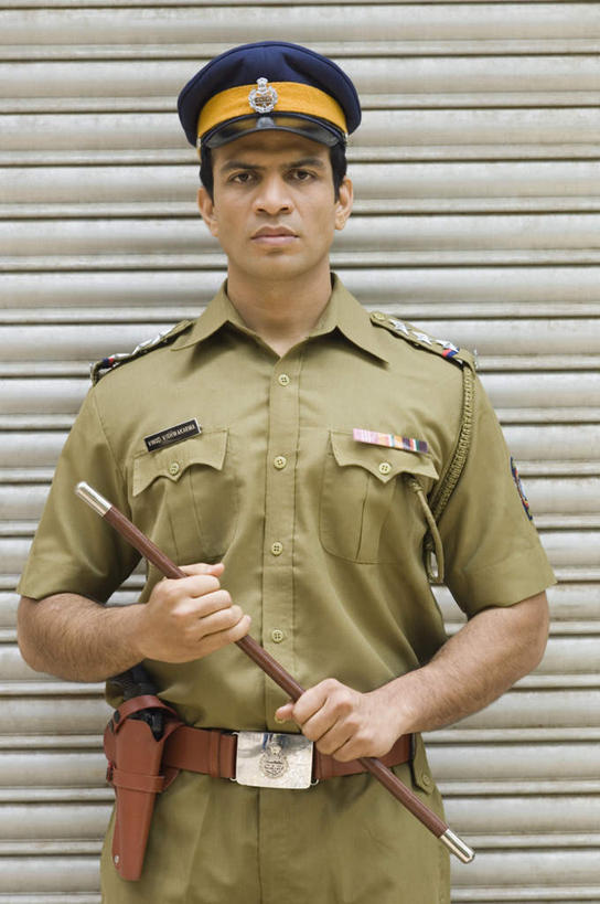 一个人,站,竖图,室外,白天,正面,工作服,制服,亚洲,仅一个男性,仅一个人,握,棍子,墙,拿,拿着,注视,墙壁,墙面,仅一个年轻男性,观察,看,站着,握着,军帽,观看,军人,察看,关注,军服,工作制服,男人,男性,年轻男性,亚洲人,印度人,站立,半身,彩图,工作套服