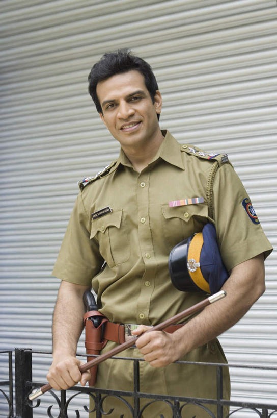 一个人,警察,警卫,栏杆,站,笑,微笑,露齿笑,竖图,室外,白天,正面,工作服,制服,竞争,亚洲,仅一个男性,仅一个人,对抗,冲突,枪支,围栏,注视,破坏,护栏,仅一个年轻男性,观察,看,站着,武器,战争,手枪,观看,损坏,察看,攻击,威胁,对立,关注,矛盾,兵器,防御,警棍,枪械,弹夹,敌对,挫败,斗争,抗拒,抗衡,杀伤,威慑,工作制服,子弹夹,危险,男人,男性,年轻男性,亚洲人,印度人,保安,警卫员,看守,卫兵,站立,半身,彩图,工作套服