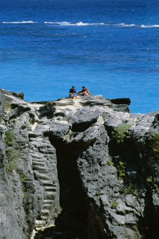 西方人,两个人,伙伴,朋友,坐,竖图,俯视,室外,白天,旅游,度假,友谊,海浪,海洋,石头,美景,植物,楼梯,英国,欧洲,欧洲人,阴影,服装,光线,石子,影子,阶梯,景观,浪花,娱乐,台阶,树,树木,衣服,绿色,阳光,自然,海水,享受,休闲,景色,大西洋,放松,服饰,生长,成长,衣着,西欧,穿着,自然风光,大不列颠,海景,大不列颠及北爱尔兰联合王国,百慕大,百慕大群岛,大不列颠联合王国,日不落英帝国,衣饰,海外领地,英国海外领地,百慕达,友情,男人,男性,女人,女性,中年男性,中年女性,白种人,大海,风浪,海,海水的波动,近岸浪,石块,岩石,涌浪,坐着,彩图,高角度拍摄,全身