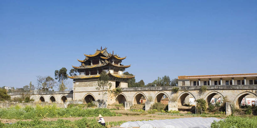 无人,横图,室外,白天,正面,旅游,度假,草地,草坪,石头,名胜古迹,植物,标志建筑,地标,建筑,中国,亚洲,阴影,遗迹,光线,石子,瓦片,影子,屋顶,桥,顶棚,瓦,古迹,文物,娱乐,建设,古建筑,石桥,云南,拱桥,栈桥,草,树,树木,蓝色,绿色,蓝天,天空,阳光,自然,天,享受,休闲,旅游胜地,放松,建造,拱形,生长,晴朗,成长,人行桥,石拱桥,古文明,东亚,屋瓦,云南省,建水,建水县,万里无云,中华人民共和国,西南地区,十七孔桥,滇,红河,红河州,红河哈尼族彝族自治州,石块,晴空,晴空万里,彩图,双龙桥