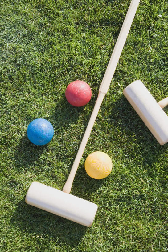 无人,竖图,俯视,室外,特写,白天,草地,草坪,植物,阴影,光线,影子,运动器械,球,草,三个,黄色,红色,蓝色,绿色,阳光,健身器械,健身器材,槌球,门球,彩图,高角度拍摄,运动器材