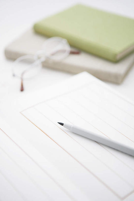 无人,竖图,俯视,室内,特写,白天,桌面,桌子,静物,阴影,朦胧,模糊,反射,木制,笔,眼镜,影子,纸,办公用品,记事本,信纸,水笔,文具,本子,笔记本,木制品,学习用品,文具用品,近视眼镜,彩图,高角度拍摄