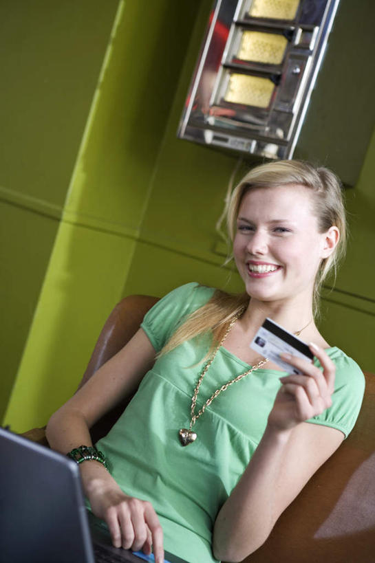 西方人,坐,笑,摸,微笑,露齿笑,竖图,室内,白天,正面,信用卡,电脑,笔记本电脑,柜子,项链,椅子,欧洲,欧洲人,抚摸,握,阴影,光线,网络,影子,墙,拿,拿着,注视,通讯设备,墙壁,墙面,装饰品,绿色,阳光,饰品,首饰,橱柜,观察,看,卡,握着,储蓄卡,观看,察看,无线,关注,通信设备,无线网络,无线上网,便携式电脑,金饰,银行卡,手提电脑,白种人,触摸,接触,坐着,半身,彩图