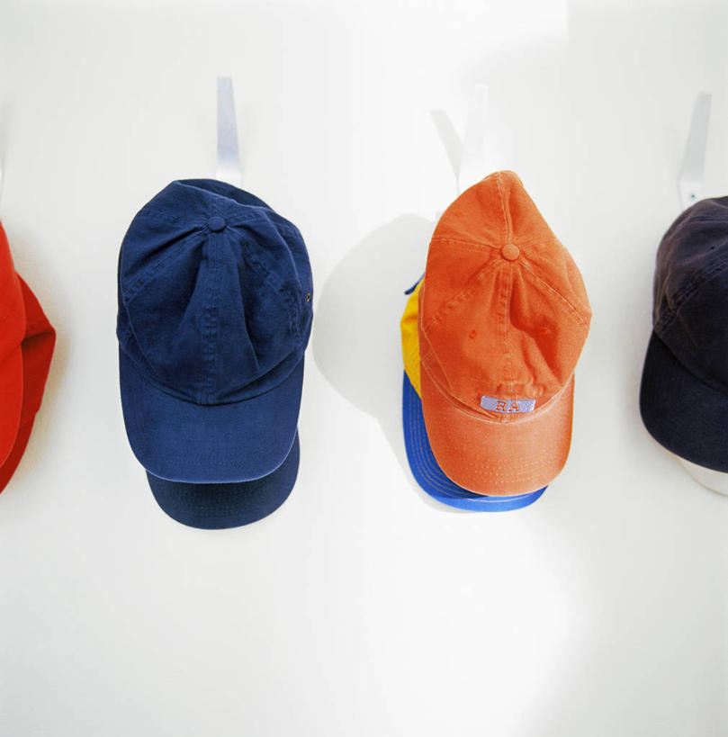 无人,竖图,室内,特写,白天,正面,静物,帽子,一排,许多,吊挂,悬挂,整齐,钩子,墙,走道,走廊,过道,很多,挂,运动帽,墙壁,墙面,排列,鸭舌帽,队列,彩图