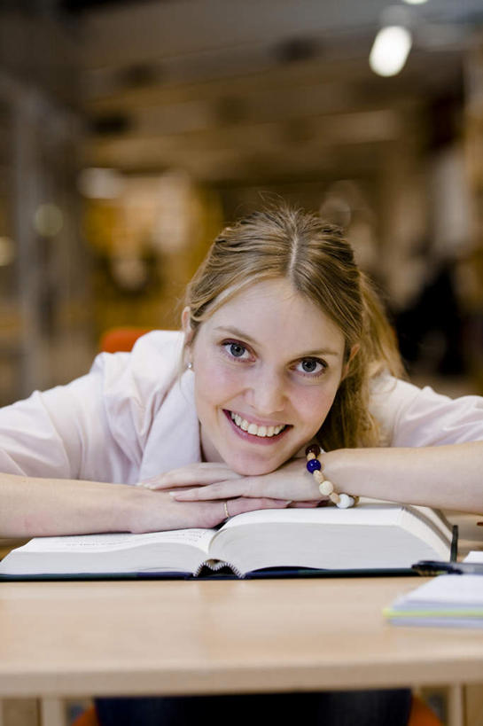 西方人,一个人,图书馆,坐,笑,双手交叉,微笑,露齿笑,竖图,室内,白天,正面,书架,桌子,书籍,欧洲,欧洲人,仅一个年轻女性,仅一个女性,仅一个人,朦胧,模糊,书桌,课桌,趴着,双手抱胸,浏览室,年轻女性,女人,女性,白种人,书,图书,趴,坐着,半身,彩图,书库,图书库,阅览室