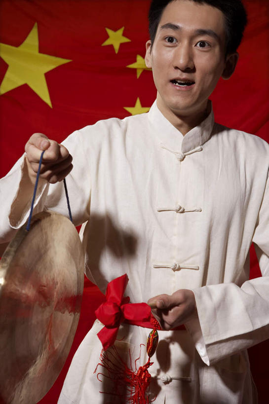 一个人,站,笑,微笑,露齿笑,竖图,室内,正面,仰视,快乐,旗帜,北京,中国,亚洲,欢呼,标语,钹,乐器,红色,看,职业,摄影,挑战,爱国主义,军号,技能,中国人,半身,彩图,低角度拍摄,影棚拍摄,传统服装,欢乐,精力