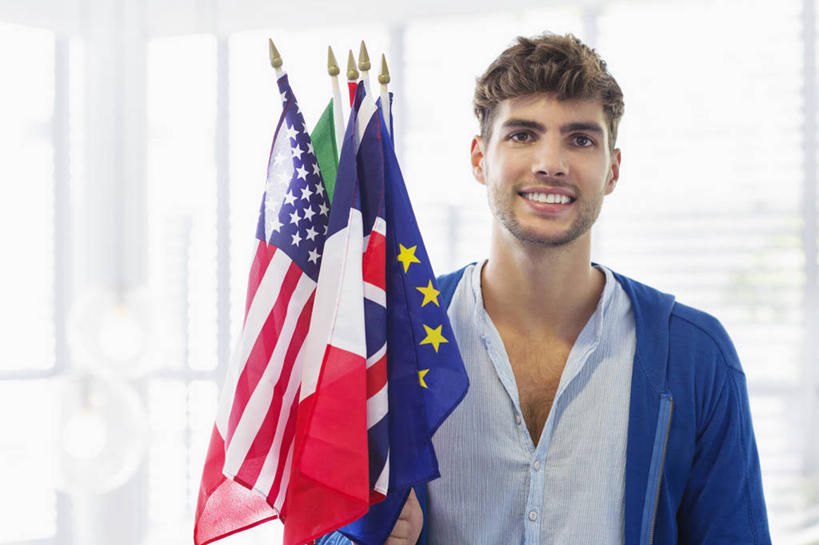 西方人,一个人,机场,站,笑,微笑,露齿笑,横图,室内,白天,正面,窗户,落地窗,飞机场,旗帜,国旗,欧洲,欧洲人,仅一个男性,仅一个人,握,阴影,服装,反射,影子,拿,拿着,注视,休闲装,星条旗,玻璃窗,仅一个年轻男性,衣服,英国国旗,观察,看,站着,休闲,休闲服,握着,美国国旗,服饰,观看,察看,米字旗,关注,意大利国旗,欧盟旗帜,男人,男性,年轻男性,白种人,航空站,空港,旗,站立,半身,彩图,美利坚合众国国旗,三色旗