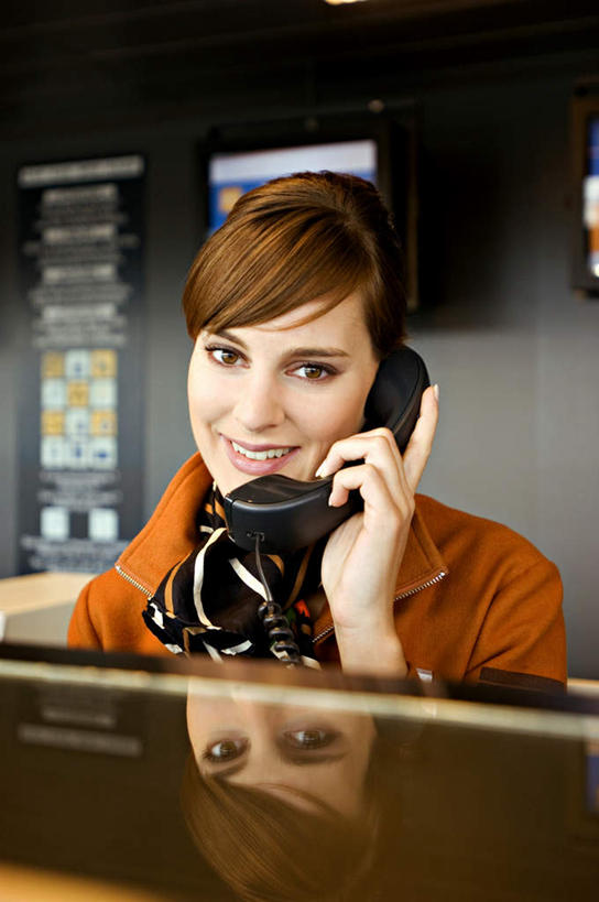 西方人,一个人,前台,地勤人员,机场,站,笑,打电话,微笑,竖图,室内,白天,正面,工作服,制服,显示器,飞机场,电话,欧洲,欧洲人,仅一个年轻女性,仅一个女性,仅一个人,阴影,朦胧,模糊,反射,领结,屏幕,影子,注视,通讯设备,标识,吊牌,显示屏,话筒,胸牌,观察,看,站着,电话线,观看,察看,徽章,固定电话,关注,身份,输出设备,胸章,胸卡,编号牌,雕刻牌,工号牌,胸号牌,胸徽,员工牌,工作制服,接待员,交流,年轻女性,女人,女性,白种人,航空站,空港,电话机,地勤,沟通,通话,站立,半身,彩图,工作套服