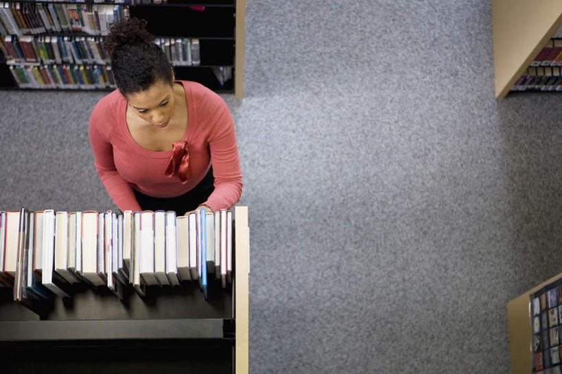 西方人,一个人,图书馆,站,横图,俯视,室内,白天,书籍,欧洲,非洲,黑人,欧洲人,仅一个女性,仅一个人,一排,许多,阴影,服装,整齐,反射,影子,走道,走廊,过道,注视,休闲装,排列,衣服,书柜,观察,看,站着,仅一个中年女性,休闲,休闲服,书橱,服饰,观看,察看,挑选,队列,关注,选择,浏览室,采选,遴选,筛选,挑拣,挑撰,女人,女性,中年女性,非洲人,书,图书,站立,彩图,高角度拍摄,全身,书库,图书库,阅览室