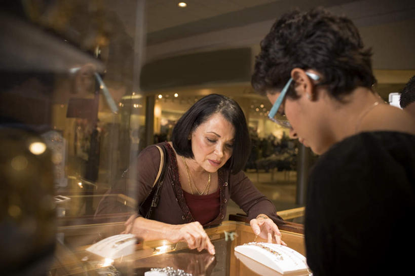 西方人,两个人,站,举,笑,微笑,露齿笑,横图,室内,白天,正面,柜子,天花板,项链,玻璃,照明,欧洲,欧洲人,握,指,阴影,服装,时间,反射,包,皮包,时钟,手表,眼镜,影子,柱子,墙,灯光,拿,计时,拿着,注视,休闲装,顶灯,架子,墙壁,墙面,玻璃制品,灯,装饰品,衣服,饰品,首饰,橱柜,灯具,钟表,低头,观察,看,托,站着,休闲,休闲服,表,握着,服饰,观看,单肩包,腕表,照亮,察看,照明设备,关注,首饰店,近视眼镜,金饰,女人,女性,中年女性,白种人,钟,举起,举手,举着,向上举,向上伸,向上托,站立,半身,彩图