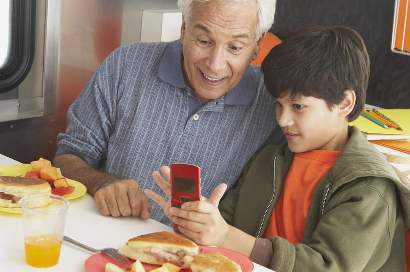 男,西方人,儿童,头发,两个人,家庭,祖父,餐厅,坐,笑,打电话,微笑,露齿笑,横图,俯视,室内,白天,烹饪,西餐,纯洁,餐桌,窗户,桌子,餐具,电话,手机,欧洲,欧洲人,敲打,握,阴影,服装,光线,碟子,盘,影子,墙,三明治,料理,食品,拿,拿着,扭头,注视,休闲装,输入,通讯设备,菜肴,美食,玻璃窗,墙壁,墙面,食物,小孩,衣服,红色,黑色,灰色,阳光,盘子,碟,快餐,打字,观察,看,靠,靠着,倚靠,转头,休闲,温暖,温馨,一家人,休闲服,可爱,童年,童趣,西式,握着,服饰,佳肴,爷爷,餐台,观看,祖孙,点击,敲击,和睦,察看,倚着,关注,童真,西式快餐,烂漫,无邪,三文治,外公,外祖父,外孙,一部,外孙子,交流,天真,按键,老年男性,男孩,男人,男性,白种人,孩子,孙子,沟通,通话,坐着,半身,彩图,高角度拍摄,餐馆,饭店,饭馆,融洽,男生