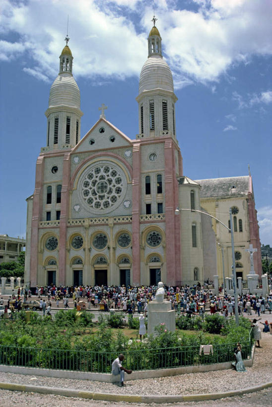 西方人,教堂,站,竖图,室外,白天,正面,旅游,度假,植物,标志建筑,地标,建筑,欧洲,海地,欧洲人,阴影,服装,节日,时间,光线,时钟,影子,云,云朵,许多人,计时,云彩,注视,休闲装,文化,娱乐,建设,树,树木,衣服,蓝色,绿色,白云,蓝天,天空,阳光,自然,钟表,天,观察,看,祈祷,站着,一群人,享受,休闲,健康,休闲服,表,旅游胜地,放松,许愿,宗教,服饰,信仰,生长,晴朗,成长,观看,纪念,祈求,察看,北美,北美洲,基督教,关注,天主教,美洲,信念,北亚美利加洲,亚美利加洲,塔钟,海地共和国,太子港,平安,男人,男性,女人,女性,中年男性,中年女性,白种人,钟,晴空,站立,彩图,全身,大教堂,礼拜堂