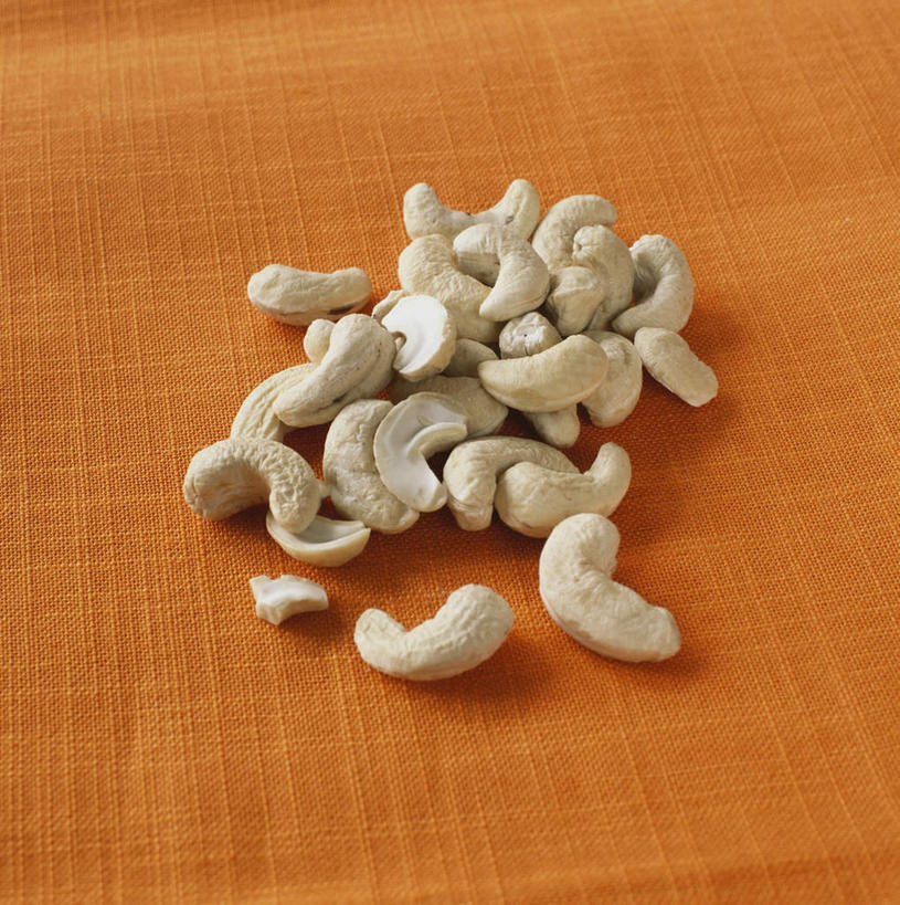 无人,竖图,俯视,室内,特写,白天,餐桌,桌子,许多,橙色背景,阴影,朦胧,模糊,光线,影子,坚果,干果,橙色,摄影,影棚,餐台,腰果,鸡腰果,介寿果,彩图,高角度拍摄,影棚拍摄,拍摄