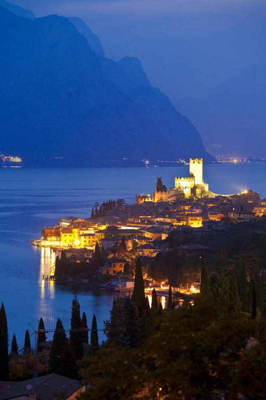 无人,家,竖图,俯视,航拍,室外,夜晚,旅游,度假,湖,湖泊,美景,山,山脉,水,植物,城市风光,城市,建筑,路灯,照明,意大利,欧洲,阴影,波纹,光线,影子,房屋,屋子,湖面,景观,山峰,水流,水面,公寓,灯光,涟漪,山峦,娱乐,建设,洋房,楼房,住宅,灯,树,树木,绿色,倒影,水纹,自然,波浪,湖水,群山,享受,休闲,景色,放松,生长,成长,照亮,倒映,照明设备,鸟瞰,南欧,伦巴第大区,意大利共和国,伦巴第,水晕,反照,布雷西亚省,贝纳科湖,加尔达湖,彩图,高角度拍摄,房子