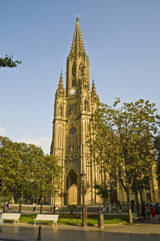 竖图,室外,白天,旅游,建筑,西班牙,行人,游客,游人,长椅,尖顶,历史,钟塔,路人,旅客,树,天空,地标建筑,摄影,基督教,巴斯克自治区,圣塞瓦斯蒂安,过客,彩图,大教堂,过去