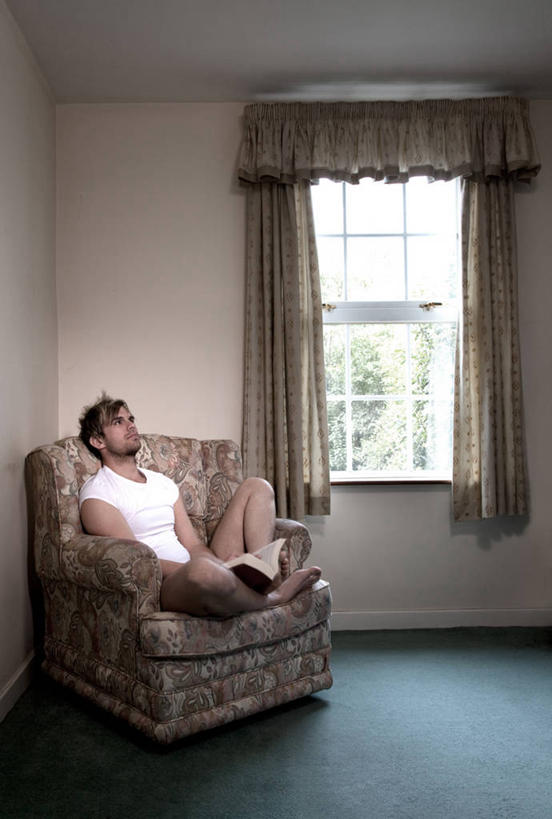 西方人,成年人,一个人,坐,竖图,室内,白天,窗户,窗帘,椅子,英国,欧洲,欧洲人,仅一个男性,仅一个人,短裤,T恤,拿着,休闲装,仅一个年轻男性,思考,放松,摄影,起居室,挑染,男人,男性,年轻男性,白种人,年轻人,书,彩图,独处,白日梦