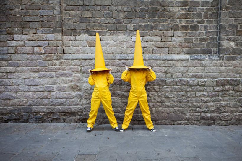 两个人,站,举,横图,室外,白天,西班牙,巴塞罗那,覆盖,墙,拿着,黄色,托,摄影,幽默,隐藏,路锥,举起,举手,举着,向上举,向上伸,向上托,彩图,巴塞罗那省