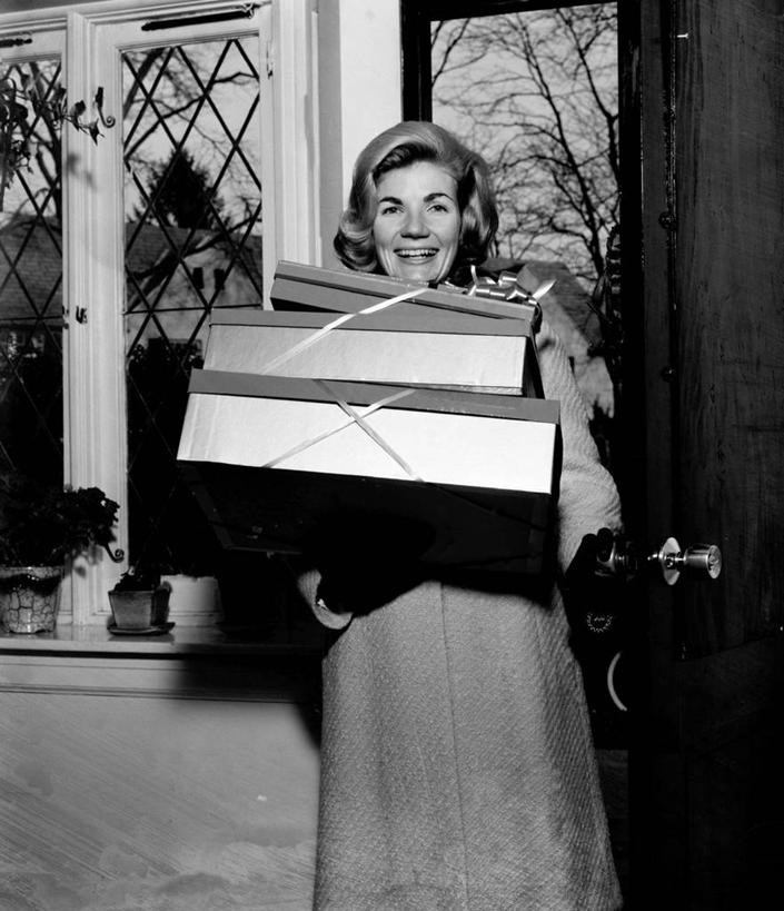 西方人,成年人,中年人,老年人,一个人,站,笑,微笑,露齿笑,竖图,黑白,室内,白天,正面,购物,快乐,幸福,消费,欧洲,纽约,美国,欧洲人,仅一个女性,仅一个人,正门,古典,拿着,盒子,三个,仅一个中年女性,摄影,高雅,抵达,女人,女性,中年女性,白种人,发型