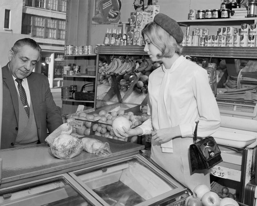 成年人,老年人,两个人,商店,横图,黑白,室内,白天,购物,蔬菜,水果,美国,商品,饮食,顾客,零售,摄影,收银台,付款,购买,出示,老年男性,男人,男性,年轻女性,年轻人,售货员,半身