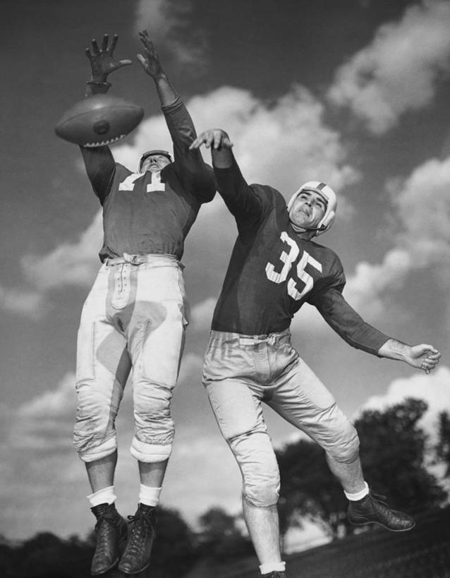 西方人,成年人,一个人,两个人,跳,竖图,黑白,室外,白天,仰视,运动服,运动,竞争,橄榄球,欧洲,欧洲人,仅一个男性,仅一个人,服装,数字,云,球场,竞技运动,半空,古典,树,仅一个年轻男性,衣服,天空,向上看,摄影,服饰,衣着,穿着,决心,努力,橄榄球运动员,美国文化,橄榄球头盔,敌对,衣饰,美式足球,男人,男性,年轻男性,白种人,年轻人,低角度拍摄,运动装