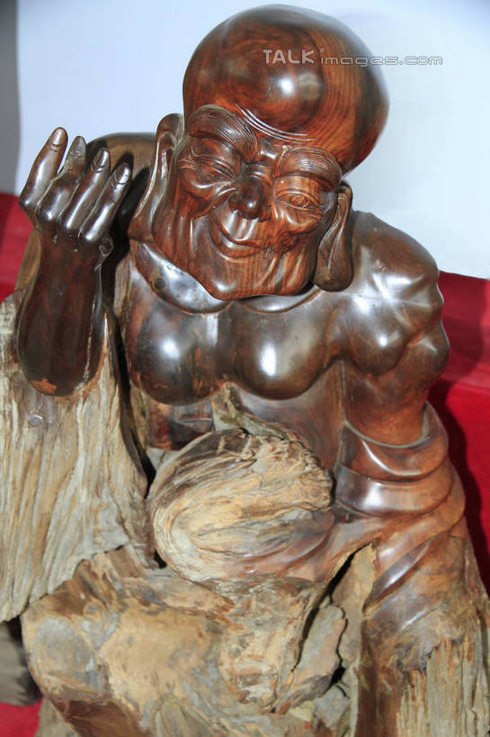 东方人,一个人,无人,和尚,坐,举,笑,微笑,竖图,室内,白天,正面,静物,雕塑,亚洲,仅一个男性,仅一个人,仅一个中年男性,阴影,节日,艺术,装饰,光线,光泽,木制,雕刻,雕像,佛像,影子,墙,棕色,织物,光芒,黄种人,文化,墙壁,墙面,红色,白色,阳光,木制品,工艺品,祈祷,托,健康,展示,许愿,宗教,根雕,佛教,信仰,纪念,展览,支撑,祈求,美术,主题,陈列,罗汉,功能,美学,释教,阿罗汉,那迦犀那,那迦犀那尊者,十八罗汉,挖耳罗汉,绒布,平安,男人,男性,中年男性,亚洲人,比丘,高僧,僧,僧侣,僧人,沙弥,修行僧,举起,举手,举着,向上举,向上伸,向上托,坐着,半身,彩图,rzwdb1