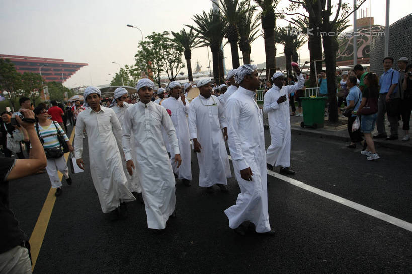 东方人,西方人,伙伴,朋友,站,走,举,笑,微笑,露齿笑,横图,室外,白天,正面,民族服装,旅游,度假,友谊,合作,团队,植物,标志建筑,道路,地标,建筑,路,公路,上海,欧洲,非洲,中国,黑人,欧洲人,亚洲,行人,游客,游人,阴影,光线,头巾,影子,分界线,停车线,交通,许多人,注视,黄种人,娱乐,建设,路人,旅客,树,树木,蓝色,绿色,白色,蓝天,天空,阳光,自然,天,观察,看,托,站着,一群人,享受,休闲,上海世博馆,世博馆,上海世博会,世博,世博会,旅游胜地,放松,战略,生长,晴朗,成长,观看,车行道,车行道分界线,申,察看,关注,标线,中国馆,东亚,车行线,世博园,上海市,万里无云,中华人民共和国,沪,华东地区,联合,合谋,中国世博馆,过客,配合,协作,男人,男性,年轻男性,年轻女性,女人,女性,非洲人,亚洲人,晴空,晴空万里,马路,步行,举起,举手,举着,向上举,向上伸,向上托,站立,走路,半身,彩图,传统服装,民俗服,shgzq1