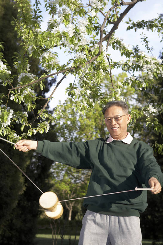 东方人,成年人,老年人,头发,一个人,站,笑,微笑,露齿笑,竖图,室外,白天,正面,游戏,快乐,满意,玩具,叶子,亚洲,仅一个男性,仅一个人,木制,瓷器,年轻,玩,拿着,休闲装,娱乐,传统,花,花朵,树,停车,绿色,自然,春天,仅一个老年男性,休闲,健康,放松,活力,平衡,生活方式,活动,宁静,琴弦,退休,专心,享乐,练习,愉悦,发泄,消遣,智力,近景,中国文化,东亚,万里无云,北京市,宣泄,空竹,技能,老年男性,男人,男性,亚洲人,中国人,年轻人,休闲活动,玩耍,嬉戏,彩图,欢乐,传统文化,人老心不老,抽陀螺,bj175
