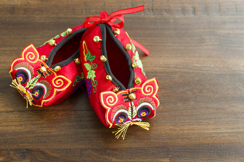 无人,横图,特写,留白,婴儿服装,纯洁,运气,复古,桌子,静物,鞋子,刺绣,北京,中国,春节,新年,亚洲,花纹,风俗,节日,庆祝,鲜艳,图案,冬天,艺术品,一对,古典,传统,两个,红色,婴儿鞋,工艺品,精神,可爱,童年,童趣,摄影,虎头鞋,褐色背景,婴儿用品,仪式,风格,中国文化,手艺,典礼,古典风格,童真,东亚,烂漫,无邪,制度,美术工艺,天真,彩图,高角度拍摄,影棚拍摄,婴儿服,传统文化,襁褓,bj175